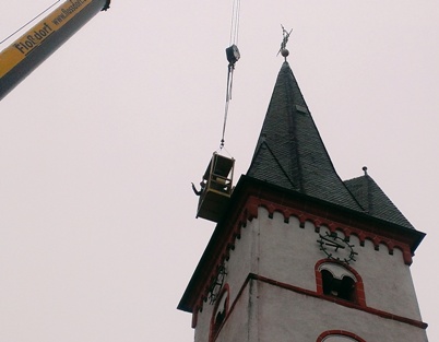 Dachdecker Martin Söhn im Arbeitskorb am Kirchturm
